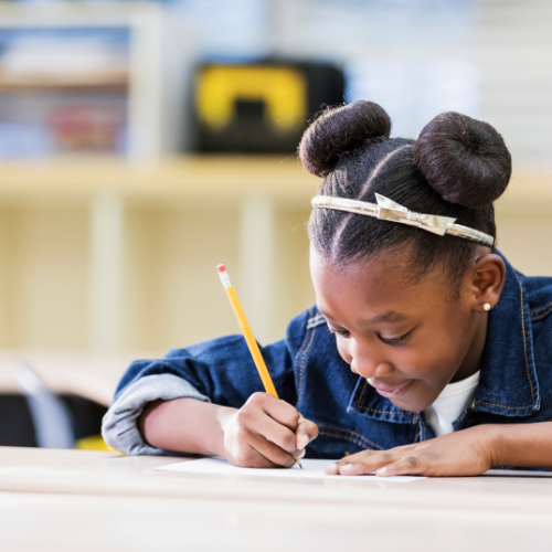 Girl writing at a desk.